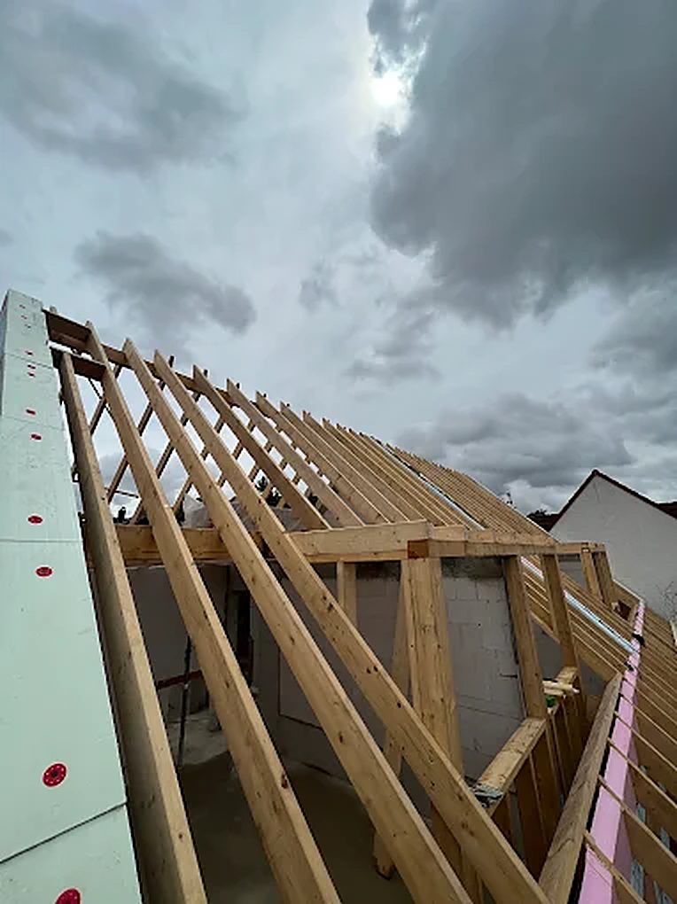 Neuer Dachstuhl aus hellem Konstruktionsholz auf einer Baustelle